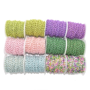 Twelve rolls of colorful faux pearl chains on spools for DIY jewelry making