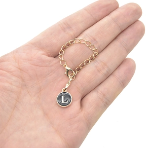 Golden keychain with black enamel letter L pendant and durable lobster clasp for bags