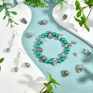 Parure bijoux gothique punk avec perles vertes et crânes en argent sur présentoir