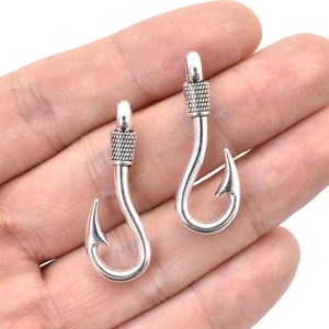 Macro view of silver fish hook pendants with intricate coil detail for jewelry DIY