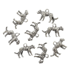 Macro detail van antieke zilveren luipaardbedeltjes met zwarte stippen voor sieraden maken