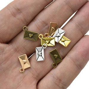 Mini-Briefumschlag-Herzanhänger in Gold, Silber, Roségold und Bronze auf Handfläche