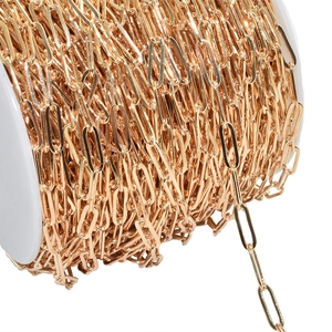 Close-up of gold paperclip chain link on white spool for jewelry making accessories