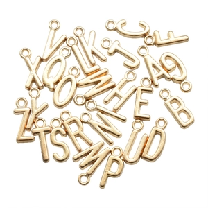 Makroaufnahme von 26 goldenen Legierungsbuchstaben-Anhängern für DIY-Schmuck
