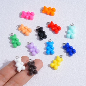 Close-up of colorful resin gummy bear charms with silver jump rings for DIY jewelry