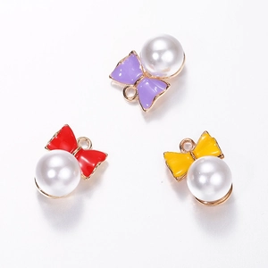Détail de breloques nœuds émaillés avec perles blanches pour bijoux DIY