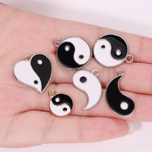 Handheld set of black and white Yin Yang enamel pendants with silver and gold alloy frames