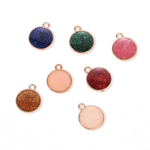 Macro view of round resin charms in seven colors with sparkling glitter and gold metal rims