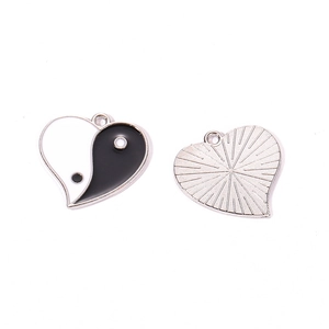 Macro detail of heart-shaped Yin Yang pendant with silver plating and drip oil craft