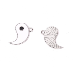 Detailed macro view of Yin Yang alloy pendant with enamel front and sunburst texture back