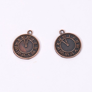 Detail showing two vintage bronze alloy clock pendants with Roman numeral engravings