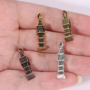 Big Ben style vintage alloy pendants in four metallic finishes shown on palm