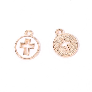Detailed macro view of gold-tone cross charms with white enamel inlay for DIY jewelry