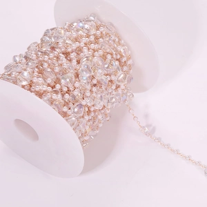 Close-up of DIY heart pearl chain with iridescent beads on white spool for jewelry making