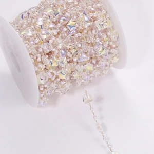 DIY jewelry chain with pearls and iridescent star heart beads on a golden chain spool