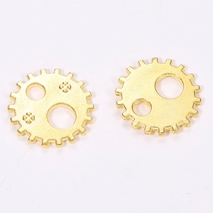 Macro detail of 12mm golden steampunk gear charms for DIY craft making and jewelry