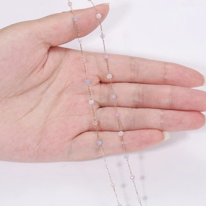 Detailansicht bunter Kristalperlen auf einer dünnen vergoldeten Kette für Schmuck