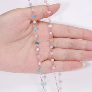 Close-up of DIY colorful heart beads and pearl chain for ethnic clothing accessories