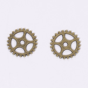 Macro view of two 15mm bronze steampunk gear pendants for DIY jewelry and crafts