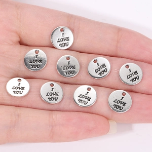 Macro shot of silver alloy I Love You round pendant charms for DIY jewelry making