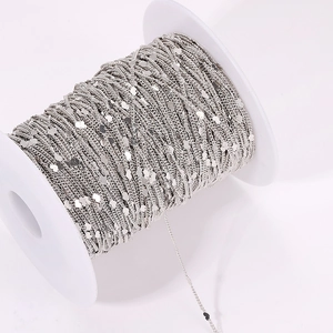 Detail of silver plated copper chain with small heart charms wound on a white plastic spool