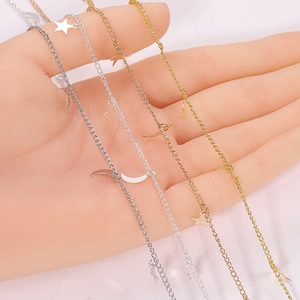 Hand holding DIY star and moon charm necklaces in gold, silver, and rose gold finishes