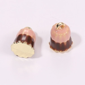 Macro shot of 3D miniature canelé dessert pendants in pink and brown enamel with gold rings