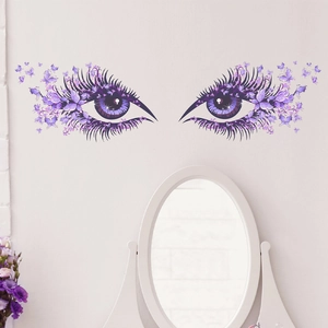 Artistic wall sticker featuring purple eyes and butterflies over a bedroom vanity mirror