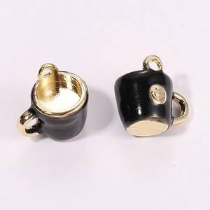 Close-up of 3D miniature black and gold coffee cup pendant with heart detail for DIY jewelry