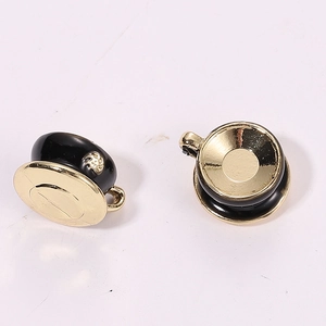 Macro detail of 3D miniature coffee cup charms in black and gold alloy for DIY jewelry making