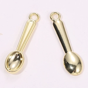 Macro view of miniature golden spoon pendants with hanging loops and handle details