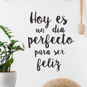 Sticker mural espagnol avec texte de motivation sur mur blanc décoré d'une plante