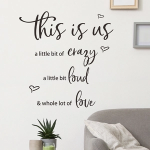 Modern black 'This is Us' wall sticker for living room with heart accents on white wall