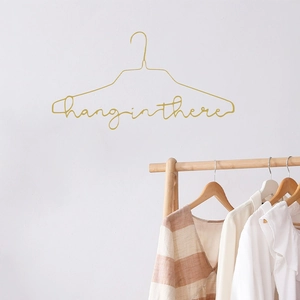 Minimalist gold metal hanger with creative 'hang in there' artistic lettering design