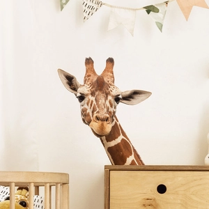 Realistic giraffe head wall decal in a warm nursery room with wooden baby furniture
