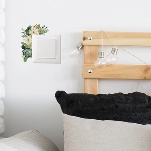 Floral wall sticker with green leaves and yellow flowers around a light switch panel