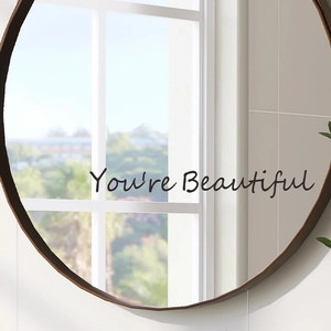 Minimalist round wall mirror with You're Beautiful decal showing natural scenery reflections