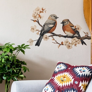 Vibrant birds and flower wall sticker displayed above a sofa in a modern cozy living room