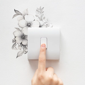 Minimalist black and white flower leaf wall sticker decorating a light switch panel