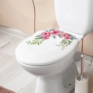 Detail of pink floral watercolor stickers on a white ceramic toilet lid for bathroom decor