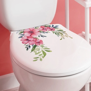 Pink watercolor flower and leaf decals on a white ceramic toilet lid in a cozy bathroom