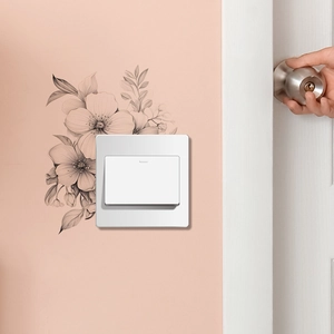 Close-up of minimalist black and white flower wall stickers around a light switch