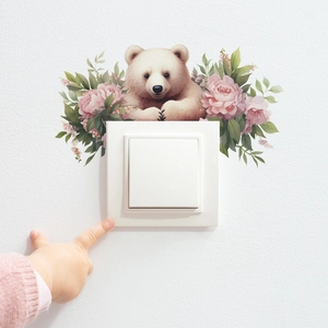Détail d'un autocollant mural avec ours et roses autour d'un interrupteur mural
