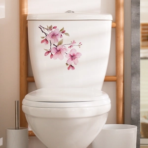 Detailed close-up of pink cherry blossom floral decals applied on a white ceramic toilet surface