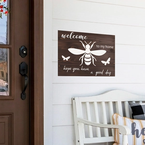 Wooden welcome sign with bees and butterfly on a white wall for home decor
