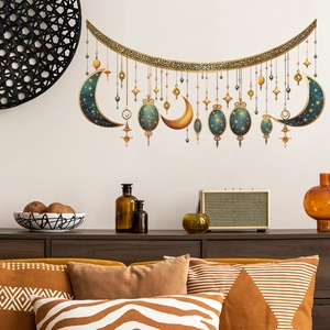 Close-up detail of hanging golden moon and lantern wall stickers on a white wall decor