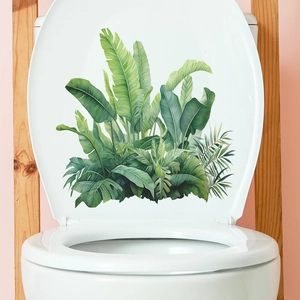 Detailansicht tropischer Monstera- und Palmblatt-Wandsticker auf einem weißen Toilettendeckel