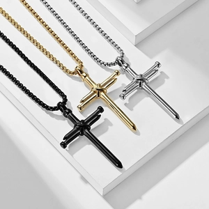 Three cross necklaces in gold, silver, and black made of stainless steel nails on stone display