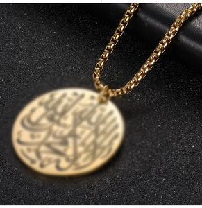 Nahaufnahme der goldenen Edelstahl-Boxkette mit arabischem Kalligraphie-Rundanhänger