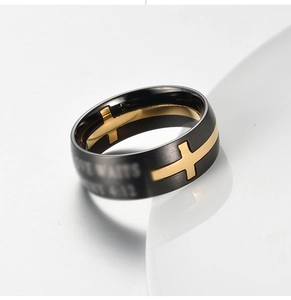 Dettaglio dell'anello in acciaio nero opaco e oro con incisione biblica 1 Timoteo 4:12